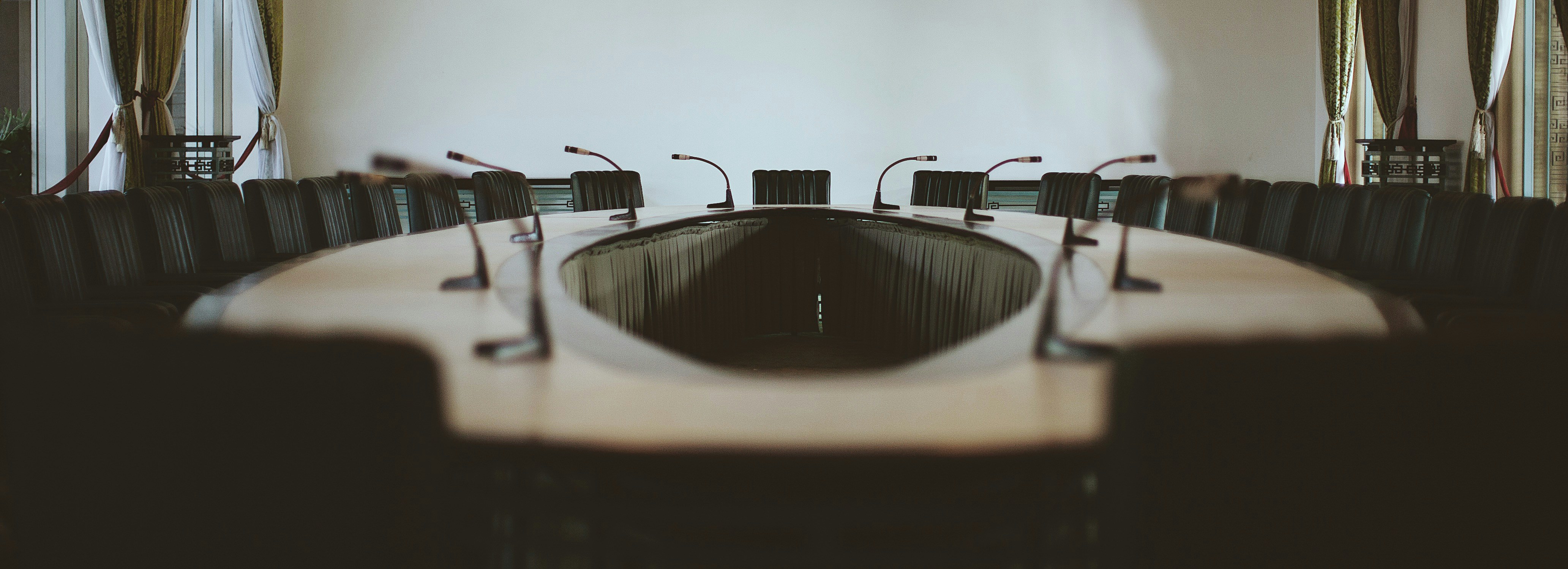 Empty boardroom table with microphones, illustrating a corporate TSCM bug sweep case study