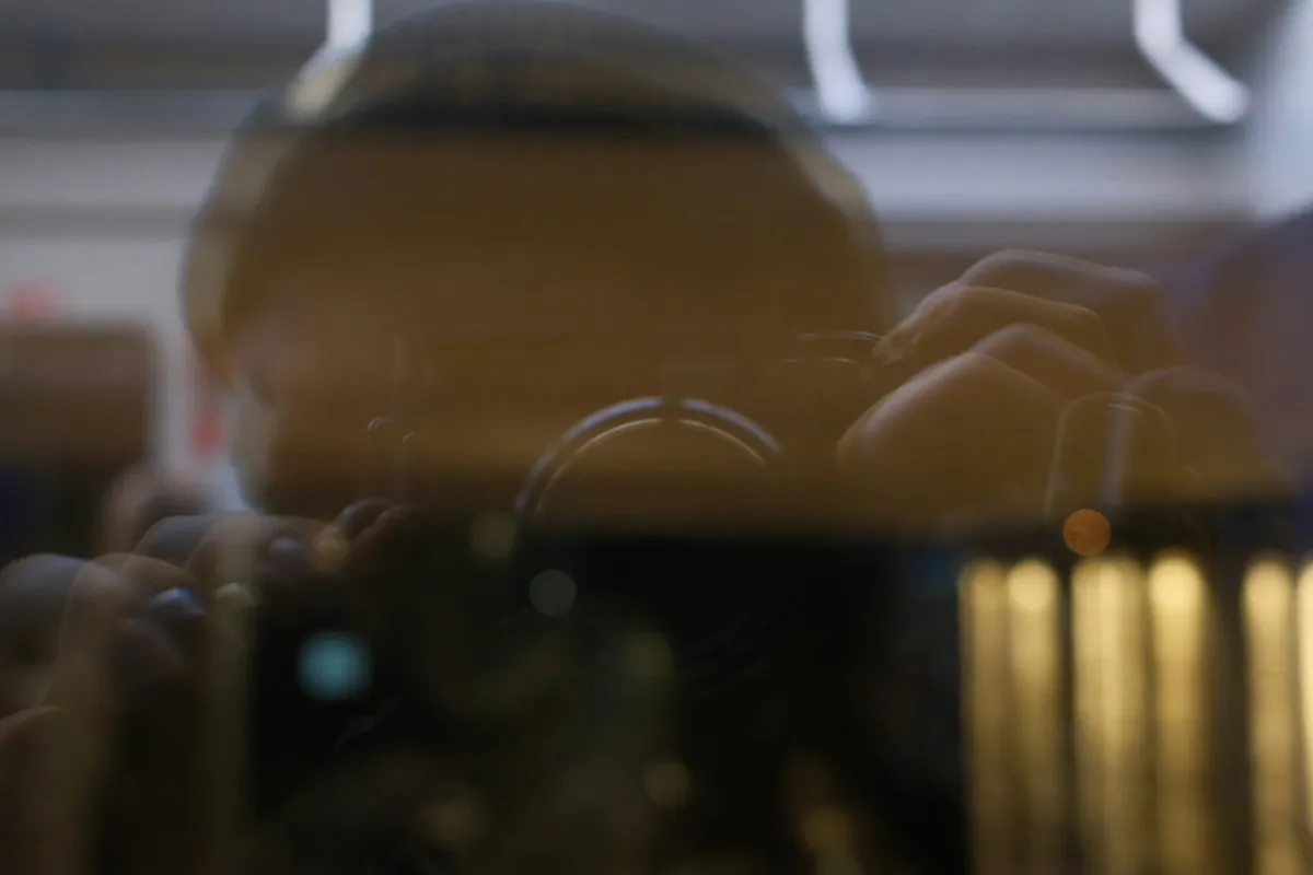 Investigator's camera reflected in glass during a Sydney surveillance job